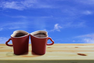Black coffee in two pink cups heart shape on wooden floor and blue sky background, Copy space or empty space for text, Valentine day The lovers are together concept.