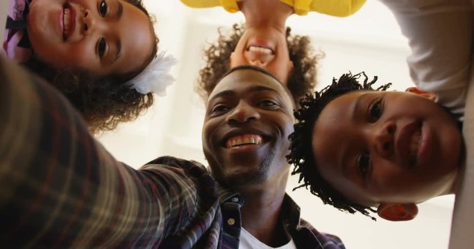 Upward view of black family unpacking cardboard boxes at comfortable home 4k