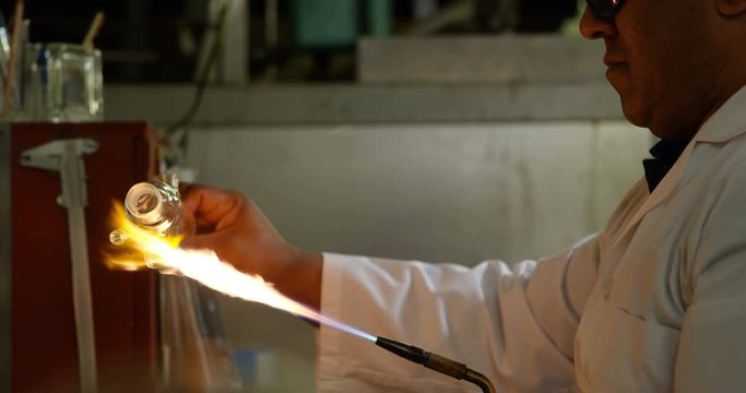 Side view of male worker creating ng glass in glass factory 4k