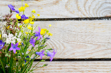Bouquet of field flowers on a wooden background.