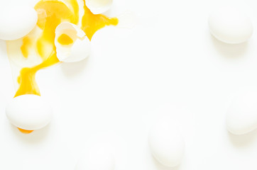 Eggs.  Eggs fresh, unharmed and one broken egg with yellow yolk on a white background. Healthy eating concept of produce organically grown.