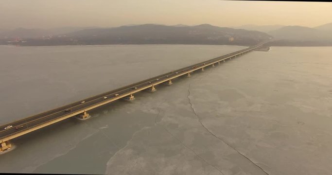 Landscape with a field of ice of the Amur Bay and the bridge Sedanka-De Vries. Vladivostok, Russia