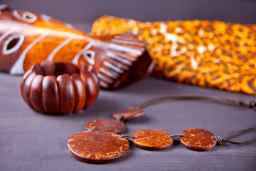 African mask, bracelet and necklace on the wooden background