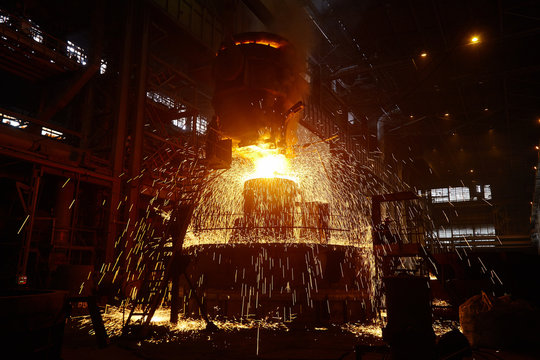 Steelmaker at ingot casting. Electric arc furnace shop EAF. Metallurgical production.