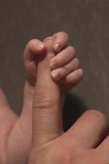 Fototapeta premium Baby umfasst Mamas Finger