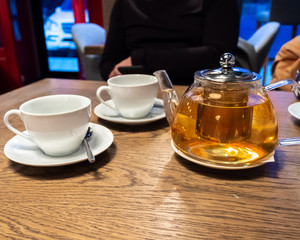 cup of tea and teapot on the table in a cafe, men