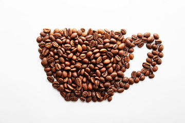 Roasted brown coffee beans scattered on white table with a lot copy space for text. Flat lay composition. Close up, top view, background.