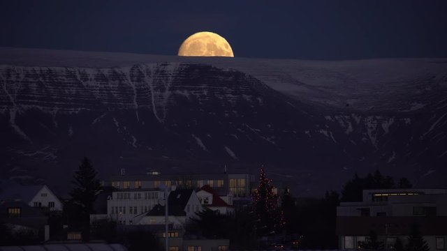 Huge full moon rising over Reykjavik Iceland bird flying by Esja mountain.mov