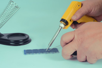 Soldering iron electronic work tool on background.