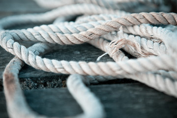 Close up of a sailing rope on a wooden pier with depth of fields 