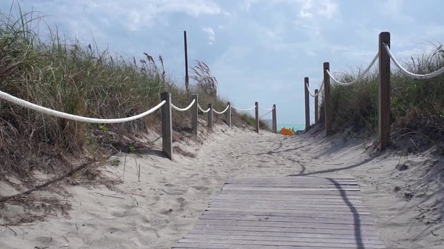 Slow motion of lucious sandy path leading to beach