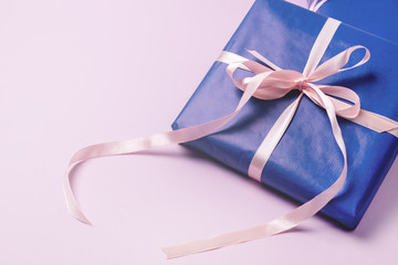 Background with Gift Boxes in Blue Wrapping Paper with Ribbons Lying on a Pink Background Horizontal Top View Flat Lay Presents Boxes Holidays Shopping Concept