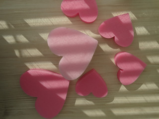 3D Heart Shapes in Various Sizes on a Wooden Background