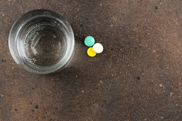 Depression concept. Psychological illness. a glass with water and a tablet on a dark background. place for text. top view