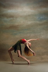 The young woman dancing in contemporary stile on gray background. Modern female dancer at studio. Elegance, grace and performance concept