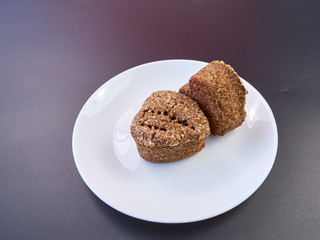 high quality dietary homemade bread on a white plate and dark background. healthy food on the table. fresh bread