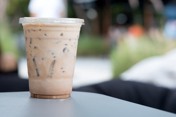 Iced coffee in a plastic glass on a table