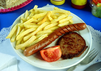 Un plato con una hamburguesa, una salchicha frankfurt y patatas fritas.