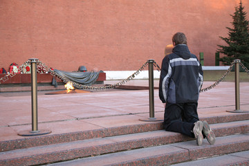 The Eternal flame near Kremlin wall in the Alexander garden. The young man knelt down as a sign of...