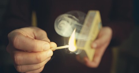 Young woman striking a match