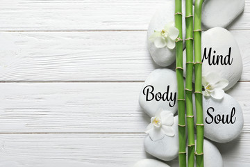 Flat lay composition with green bamboo stems on wooden background. Space for text