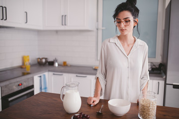 Obraz na płótnie Canvas Beautiful young woman making breakfast in the kitchen