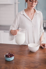 Beautiful young woman making breakfast in the kitchen
