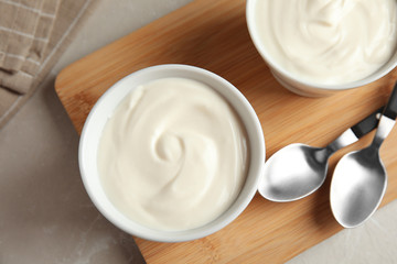 Bowls with creamy yogurt served on table, top view