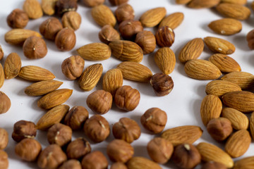  handful of nuts on a white background, almonds and hazelnuts