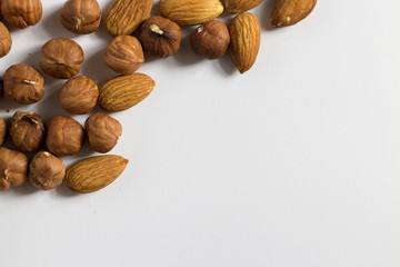  handful of nuts on a white background, almonds and hazelnuts