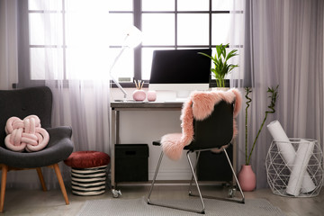 Stylish workplace with computer near window at home office. Space for text