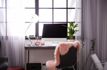 Stylish workplace with computer near window at home office. Space for text