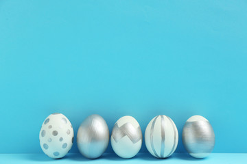 Painted Easter eggs on color background, space for text. Stylish design