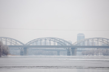 Winter is cloudy weather. The southern suburbs of Kyiv is called Bereznyaky on the left bank of the Dnipro River. Danytskyi bridge, Paton bridge. Ukraine Feb. 6, 2019