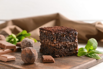 Piece of tasty chocolate cake on wooden board