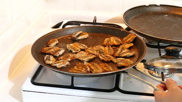 fish cooked in oil with pan, fishes cooked in the pan, close-up, fried fish,