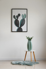 Stool with vase on rug near white wall