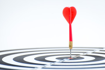 Close up shot red dart arrow on center of dartboard, metaphor to target success, winner concept, Isolated on white background with clipping path 