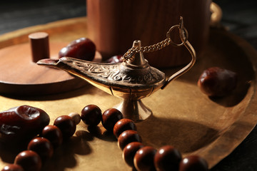 Aladdin lamp of wishes and tasbih on metal tray