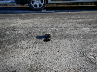 Hole in asphalt pavement, drilled cylindric specimen for laboratory testing.