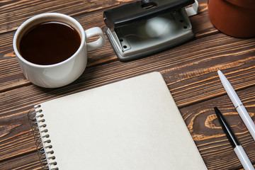 Stationery with cup of coffee on wooden table. Concept of business planning