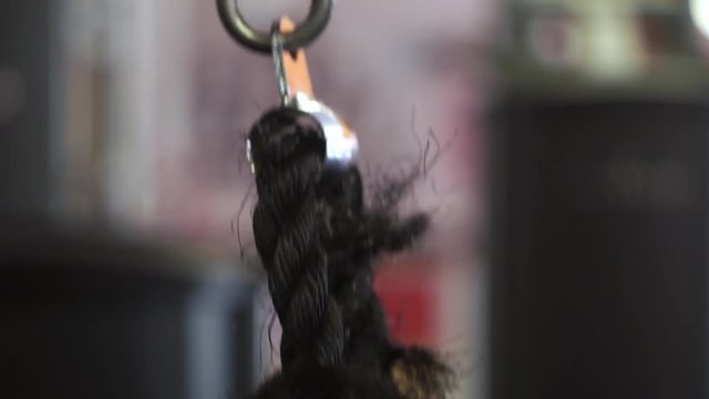 Close up man's hands grabbing rope for triceps workout in the gym. Shallow depth of field.