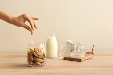 Female hand with tasty Italian biscotti in jar on table