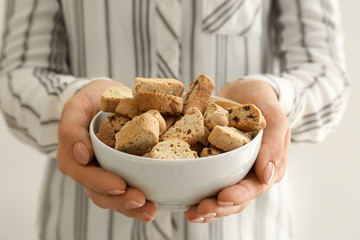 Woman with tasty Italian biscotti in bowl, closeup