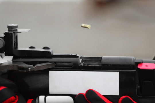 Close - up of the hand of the shooter and the rifle from which the sleeve flies