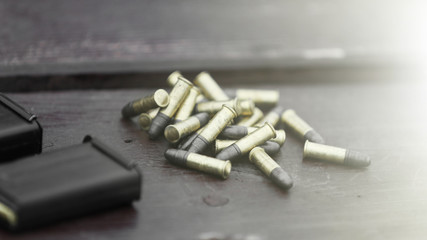Small caliber cartridges for rifle and shops on wooden background
