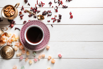 Composition with cup of tea and rahat lakoum on white wooden table