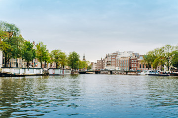 Amsterdam, Netherlands September 5, 2017: Reflection of trees and houses in still water of Amstel river, Amsterdam, Netherlands.