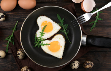 Valentines breakfast in heart shaped cast iron pan of two raw eggs and yolks