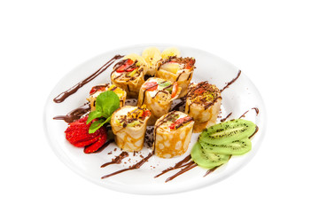 Tasty roll of pancakes with fruits and berries isolated on White Background. Fresh Homemade Crepes